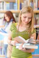 Teenage student with book at high school library