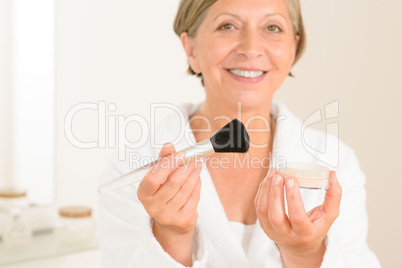 Mature woman hold brush and make-up powder