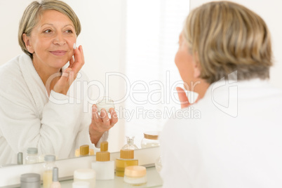 Senior woman reflection in bathroom mirror