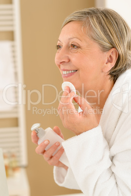 Senior woman in bathroom use cotton pad
