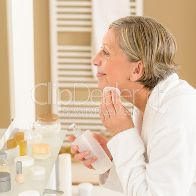 Senior woman apply face cleaning lotion