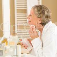 Senior woman apply face cleaning lotion