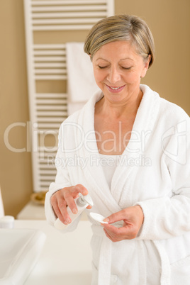 Senior woman bathroom apply face make-up removal