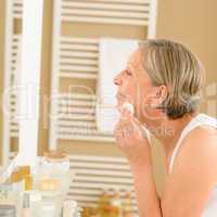 Senior woman clean face with cotton pad