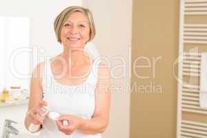 Senior woman smiling in bathroom morning hygiene
