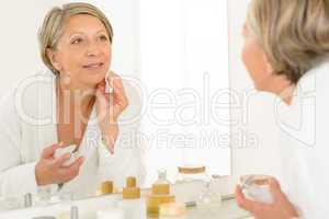 Senior woman look at herself bathroom mirror reflection
