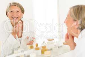 Senior woman smiling bathroom mirror reflection