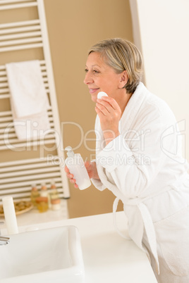 Mature woman bathroom clean face make-up removal