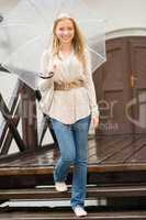 Woman stepping down the stairs with umbrella