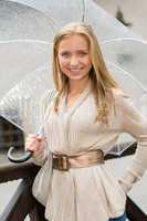 Young happy woman in rain with umbrella
