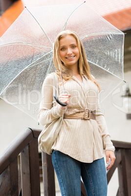 Young happy woman in rain with umbrella