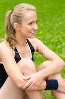 Young woman resting after workout on lawn