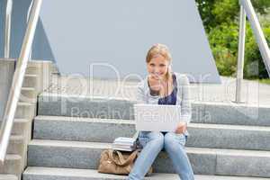 Young student woman sitting on university steps