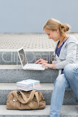 Student woman sitting on steps work laptop