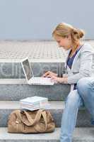 Student woman sitting on steps work laptop