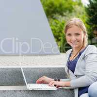 Student girl sitting on steps with laptop