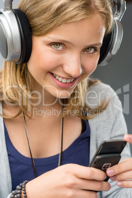 Teenage girl checking her mobile phone smiling