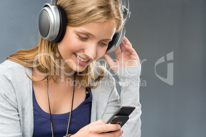 Young woman with headphones checking mobile phone