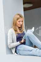 Student girl reading book outside of university