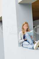 Young woman reading book outside of school
