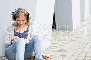 Student girl writing and listening to music