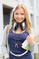 Young teenage student girl with books headphones