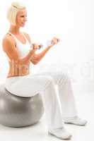 Woman dumbbells ball exercise at white fitness