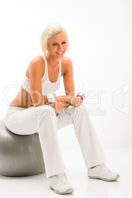 Woman with dumbbells relax on fitness ball