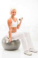 Woman dumbbells ball exercise at white fitness