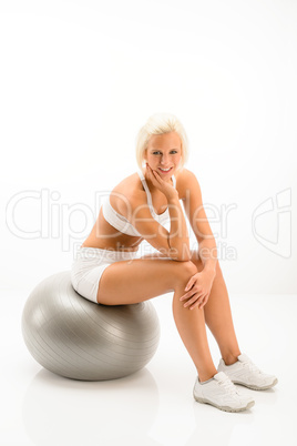 Woman sitting on pilates ball white fitness