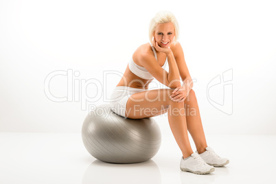 Woman sitting on Pilates ball white fitness