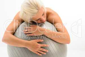 Tired sportive woman resting on fitness ball