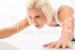 Woman doing push-ups exercise on white floor