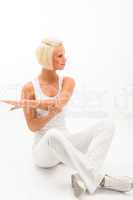 Female fitness instructor stretching arms on white