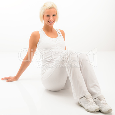 Fitness woman posing sitting on white floor