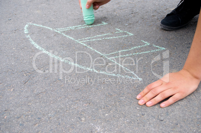Kind malt mit Straßenkreide