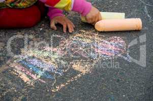 Kind malt mit Straßenkreide