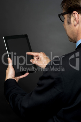 Rear view of boss browsing on new tablet pc