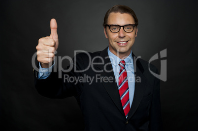 Businessman showing thumbs up sign to his team