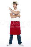 Man wearing a hat and apron pointing away