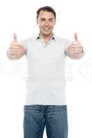 Good looking cheerful man showing double thumbs up