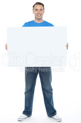 Handsome casual guy holding blank ad board
