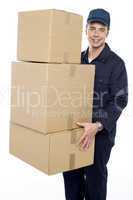 Working man delivering stack of cardboard boxes