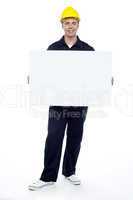 Repairman holding blank billboard, full length portrait