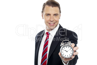 Smiling young consultant showing alarm clock