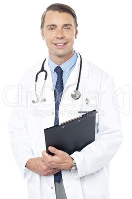 Smiling professional physician carrying clipboard