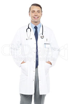 Young doctor posing with hands in his overcoat