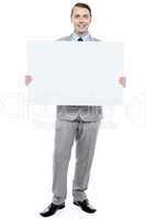 Successful business executive holding blank ad board