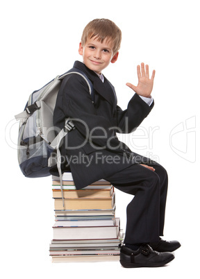 Schoolboy sitting on books