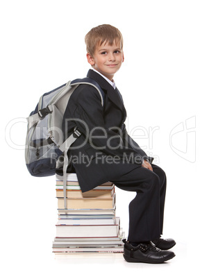 Schoolboy sitting on books